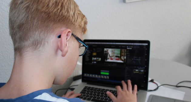 Ein Kind sitzt vor einem Laptop beim Einführungsworkshop in den Videoschnitt.