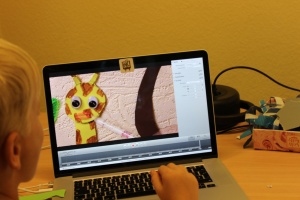 Kind am Computer - auf dem Bildschirm ist Giraffe Dennis zu sehen