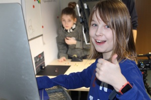 Ein Junge am Rechner und ein Mädchen das Figuren für einen Trickfilm bewegt.