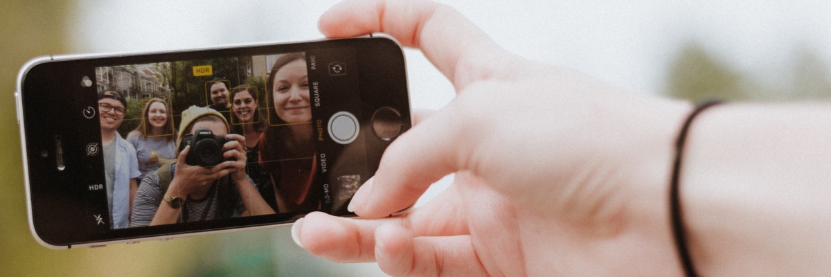 Stimmungsbild: Eine Hand hält ein Smartphone und macht ein Selfie